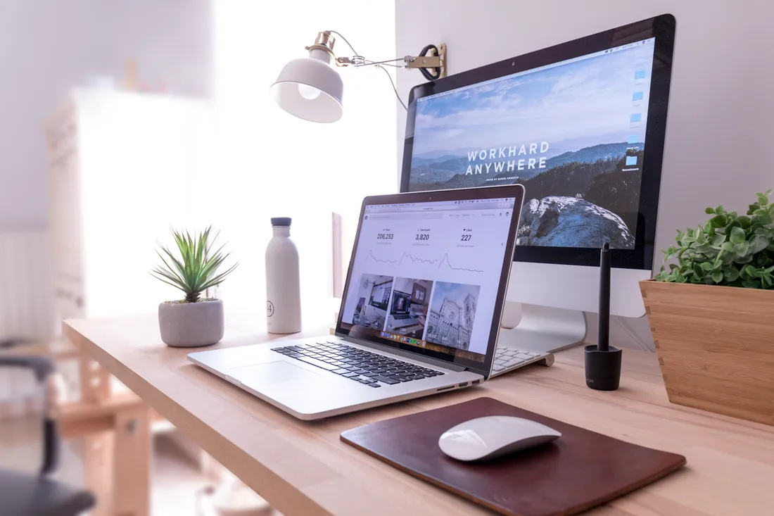 Desk with a laptop and monitor used for web design work